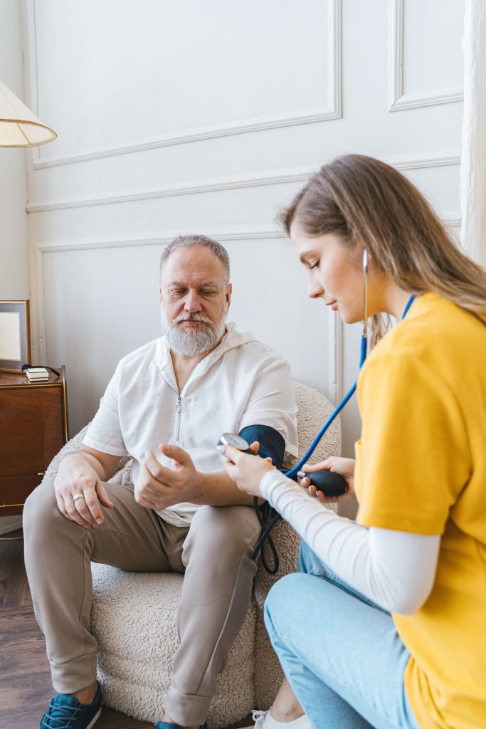 Senior visite à domicile infirmière prise de tension